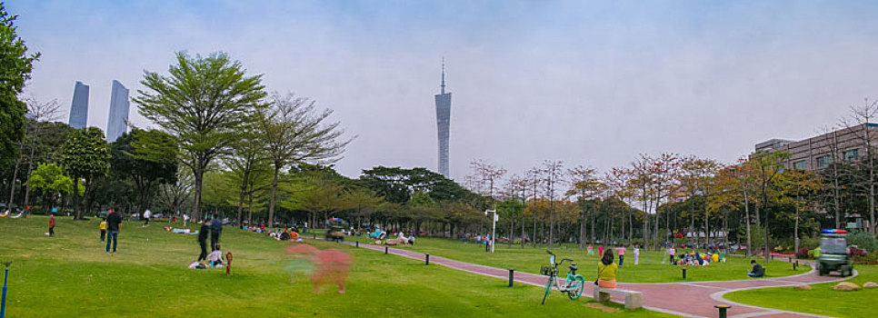 广州春天二沙岛公园草地上休闲的市民远眺珠江新城小蛮腰