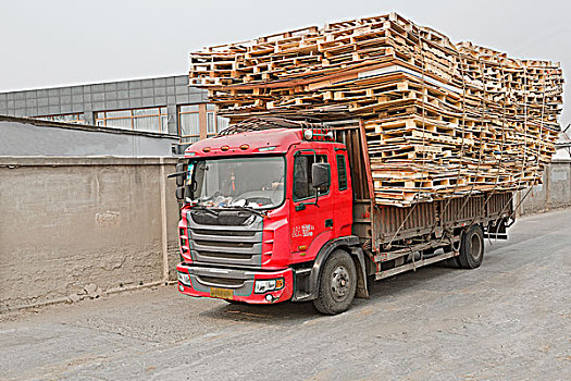 满载木包装托架的卡车正在行驶中atruckindrivingwithfullloadedwoodenpackagebases