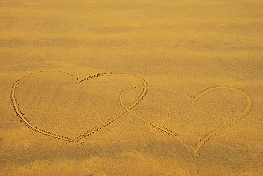 海边沙滩上两个交织在一起的心形图案
