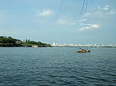 一艘游船行驶在杭州西湖湖面上