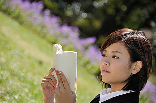 年轻女性在公园里读书