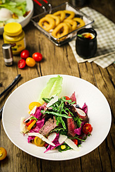 木桌子上的一盘牛肉蔬菜沙拉