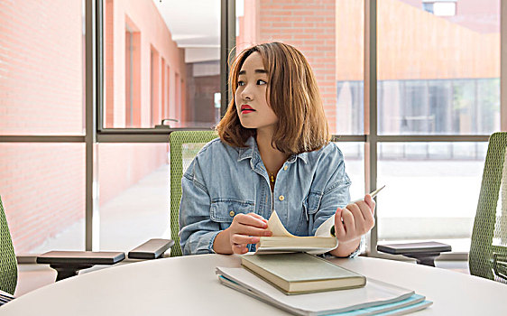 在圖書館看書學習的女大學生