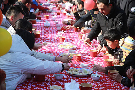 小镇摆下百米长桌宴,市民游客新年吃饺子交好运