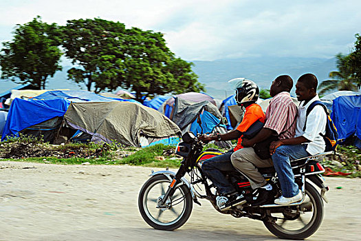 haiti,port,au,prince,3,man,on,bike,going,through,camp