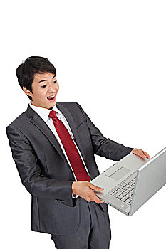 棚拍商务装年轻男人拿着笔记本电脑