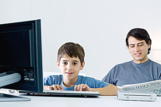 小男孩,用电脑,看镜头,微笑,父亲,读报,背景