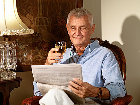 老人,坐,椅子,读,报纸,葡萄酒杯,手
