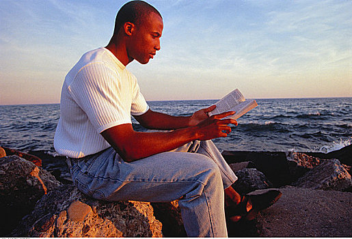 男人,坐,岩石上,靠近,水,读,书本