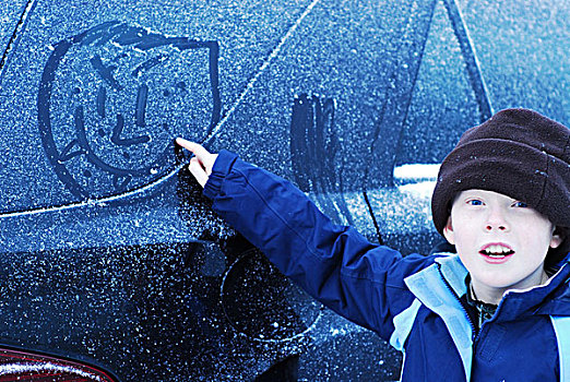 iceland,reykjavik,portrait,of,boy,drawing,with,snow,on,car