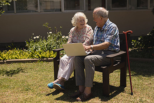 正面,老年,夫妻,坐,长椅,使用笔记本,花园