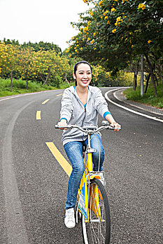 一个年轻女大学生在校园里骑车