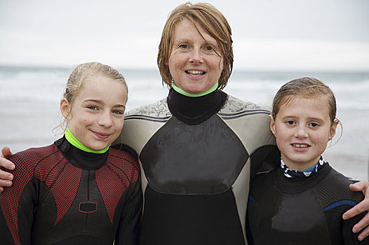 女人,两个女孩,穿,冲浪,紧身潜水衣,站立,海滩,微笑