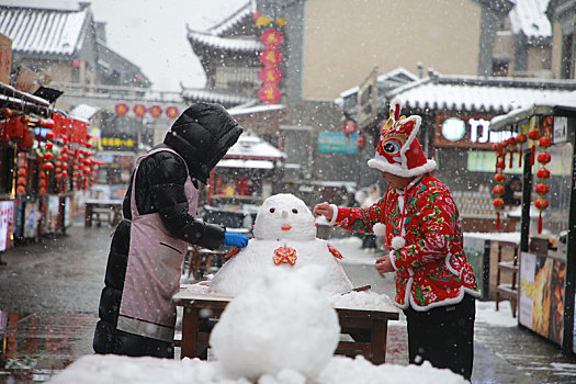 旅游小镇喜迎瑞雪,游客堆雪人寻找童年回忆