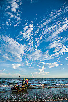广西东兴京族万尾岛金滩渔民在海涛中拖网捕鱼