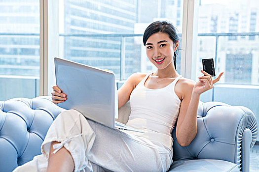 年轻女子在沙发上使用电脑