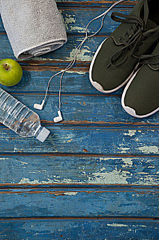 俯视,运动鞋,餐巾,耳机,水瓶,木桌子