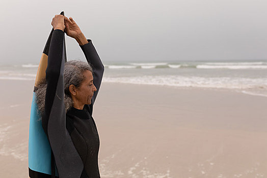 老年妇女,冲浪,抬臂,拿着,冲浪板,海滩