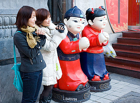 北京王府井步行街上的游人和塑像在合影