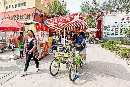 河北馆陶国庆节,黄金周,游客骑双人自行车游览,粮画小镇