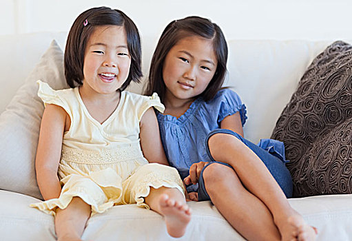 两个女孩,坐,沙发,旁侧,微笑