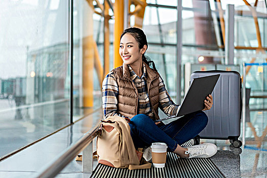年轻女子在机场使用电脑