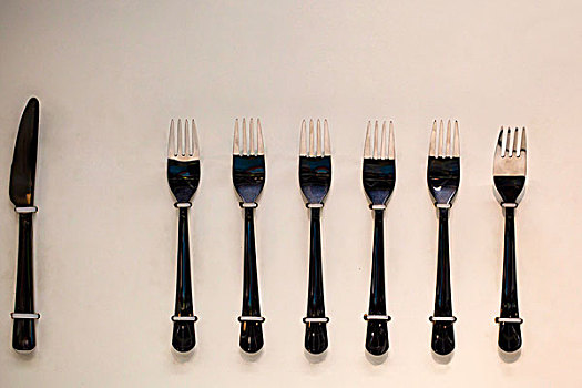一排整齐的金属餐具刀叉
