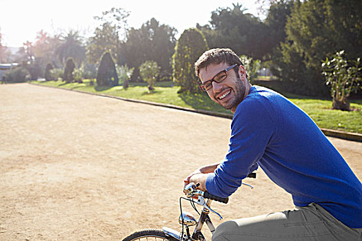 中年,男人,坐,自行车,公园,看镜头,微笑