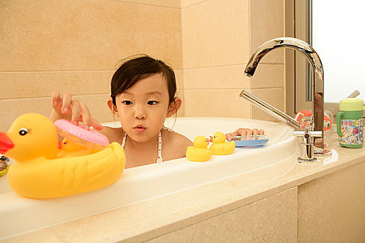 一个小孩在浴缸里玩玩具