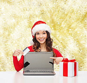 圣诞节,休假,科技,购物,概念,微笑,女人,圣诞老人,帽子,礼盒,信用卡,笔记本电脑,指向,上方,黄光,背景