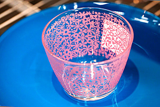 一个透明的装饰有粉色花纹的玻璃水杯