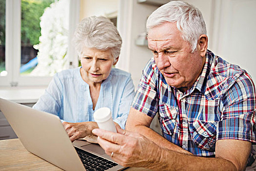 老年,夫妻,拿着,药瓶,操作,笔记本电脑,讨论