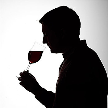 剪影,一个年轻男子肖像,闻,一杯红葡萄酒