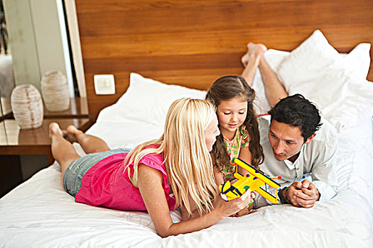年轻家庭,躺着,床,玩,玩具飞机