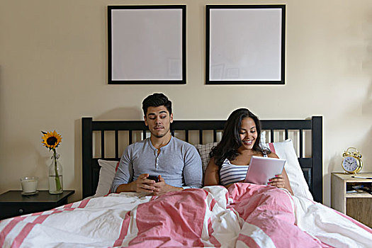 年轻,情侣,卧,床上,智能手机