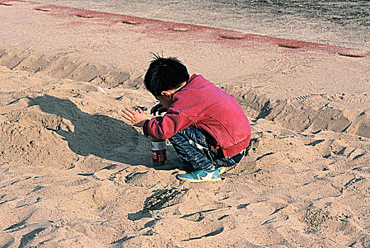玩沙子的小男孩