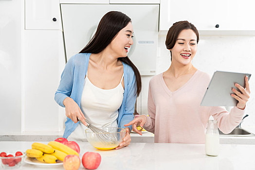 年轻女子在厨房边做饭边和朋友聊天