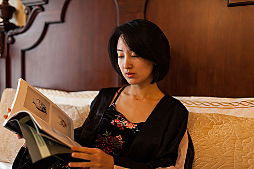 一个年轻女子在床上看书休闲