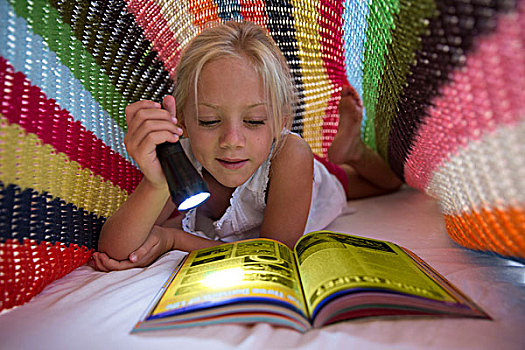 女孩,躺着,床,隐藏,毯子,手电筒,读,杂志