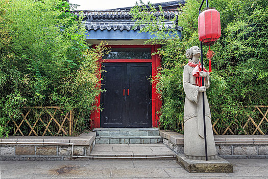 竹林前举着红灯笼的侍女石雕像,济南大明湖公园