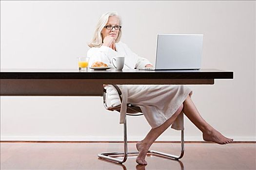 中年,女人,坐,桌子,早餐,笔记本电脑