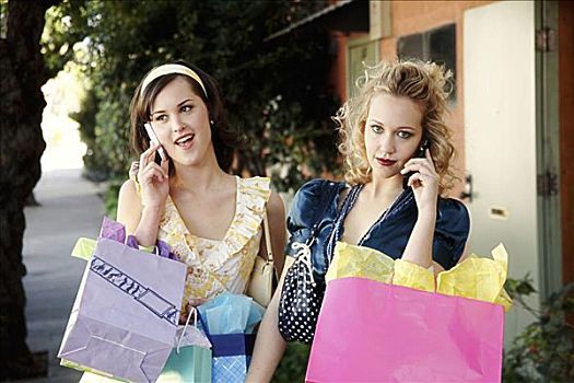 两个,女青年,交谈,手机,拿着,购物袋