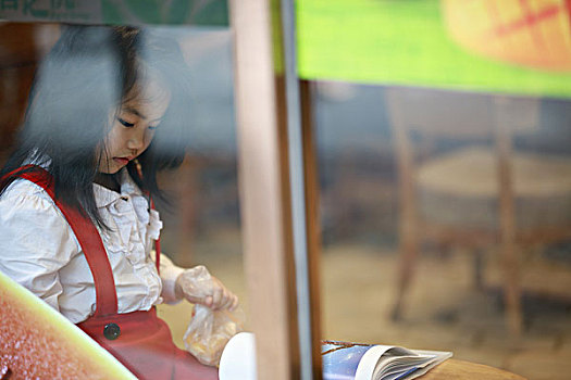 落地窗后读书的女孩