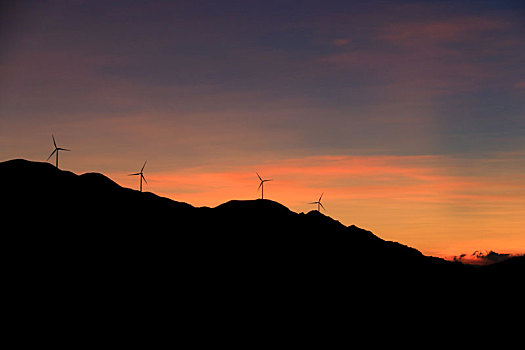 晚霞中高山上的风力发电机组