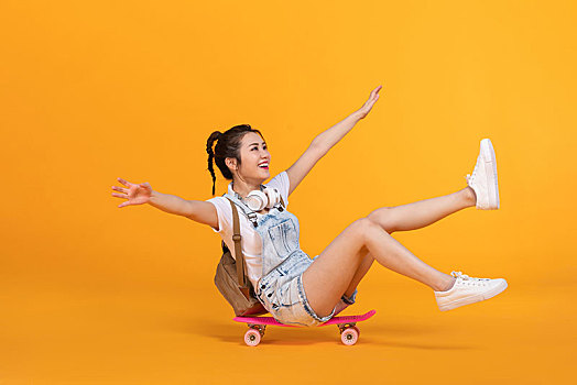 棚拍玩滑板的年輕女子