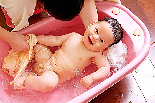 妈妈给男婴盆浴