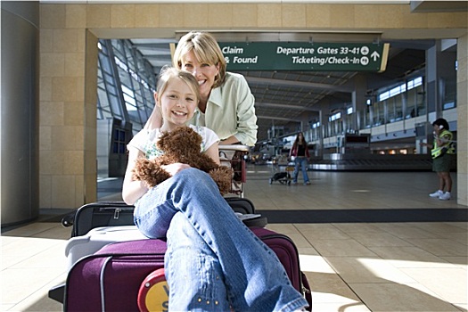 女人,站立,旁侧,行李车,机场,女儿,7-9岁,坐,手提箱,毛绒玩具,微笑,正面,头像
