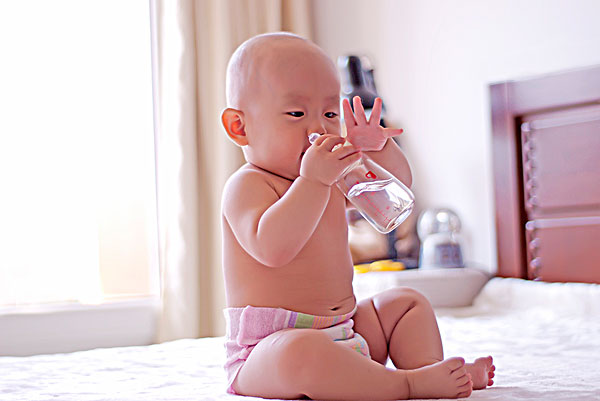 抱着水瓶喝水的婴儿