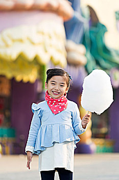 小女孩在游乐园吃棉花糖