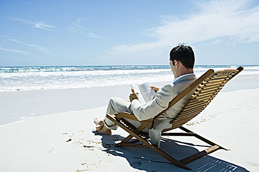 商务人士,坐,折叠躺椅,海滩,读,书本